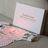 Lerelle Beauty LED therapy mask on a beige surface with packaging and accessories.