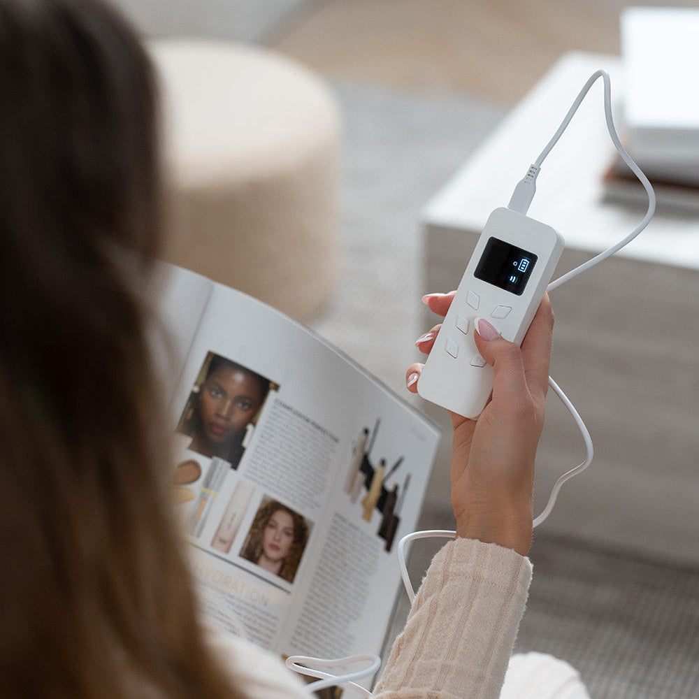 Person holding led mask remote control with a magazine open  in the background